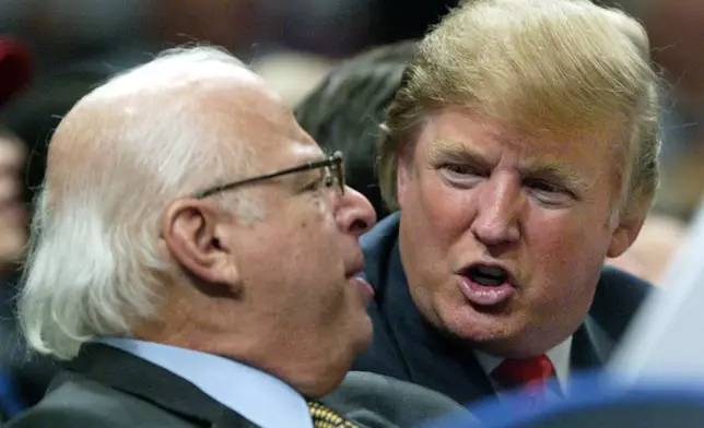 FILE - Donald Trump, right, talks to an unidentified man from the stands at Madison Square Garden during the New York Knicks game against the Dallas Mavericks on Jan. 11, 2006, in New York. (AP Photo/Kathy Willens, File)