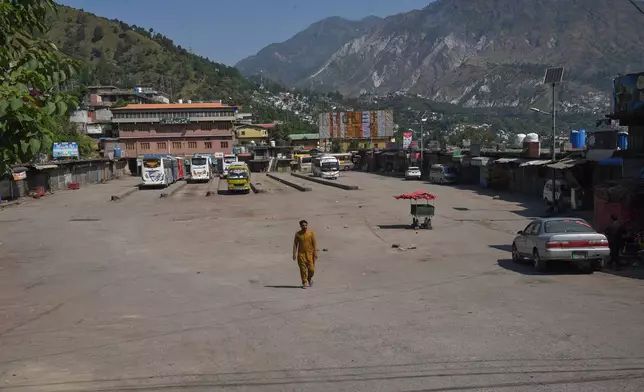 A local resident walks through a deserted bus terminal during a strike called by an outlawed alliance of activist groups "Joint Awami Action Committee" (JAAC) demanding greater political rights and the abolition of 12 legislative refugee seats, in Muzaffarabad, the capital of Pakistan-administered Kashmir, Tuesday, June 9, 2026. (AP Photo/M.D. Mughal)
