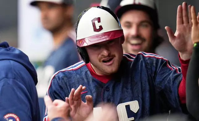 Cleveland Guardians' Kyle Manzardo celebrates in the dugout after scoring on a double hit by Kahlil Watson in the first inning of a baseball game against the Seattle Mariners in Cleveland, Friday, June 26, 2026. (AP Photo/Sue Ogrocki)