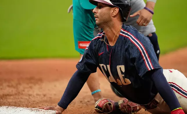 Cleveland Guardians' Brayan Rocchio, right, is picked off of first base by Seattle Mariners first baseman Josh Naylor, left, in the fourth inning of a baseball game in Cleveland, Friday, June 26, 2026. (AP Photo/Sue Ogrocki)