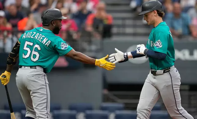 Seattle Mariners' Colt Emerson, right, is congratulated by Randy Arozarena (56) after hitting a home run in the third inning of a baseball game against the Cleveland Guardians in Cleveland, Friday, June 26, 2026. (AP Photo/Sue Ogrocki)