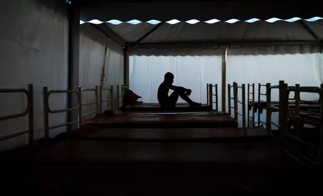FILE - Mamadou Patherazi, from Guinea, sits on a bench at the Modern Christian Mission church in Fuerteventura, Canary Islands, Spain, on Aug. 22, 2020. (AP Photo/Emilio Morenatti, File)