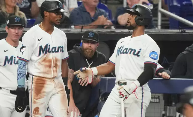 Miami Marlins' Esteury Ruiz, talks to Otto Lopez after scoring on a hit by Joe Mack during the fifth inning of a baseball game against the Tampa Bay Rays Saturday, June 6, 2026, in Miami. (AP Photo/Marta Lavandier)