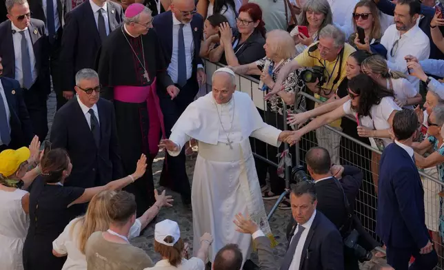 Faithful reach out to Pope Leo XIV as he leaves Pavia Cathedral in northern Italy, Saturday, June 20, 2026. (AP Photo/Antonio Calanni)