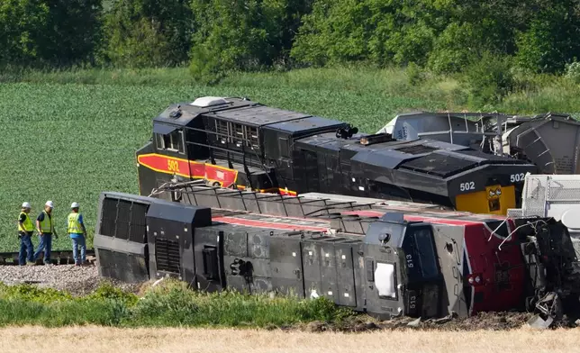 Workers respond after a train derailed on Wednesday, June 3, 2026, near Victor, Iowa. (AP Photo/Charlie Neibergall)