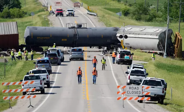 Workers respond after a train derailed on Wednesday, June 3, 2026, near Victor, Iowa. (AP Photo/Charlie Neibergall)
