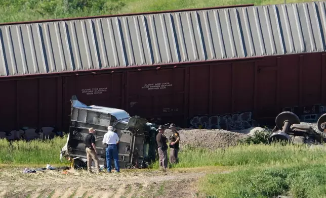 Workers and law enforcement examine debris from a semi-truck after a train derailed on Wednesday, June 3, 2026, near Victor, Iowa. (AP Photo/Charlie Neibergall)