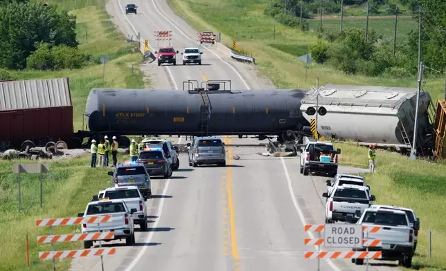 Workers and law enforcement respond after a train derailed on Wednesday, June 3, 2026, near Victor, Iowa. (AP Photo/Charlie Neibergall)