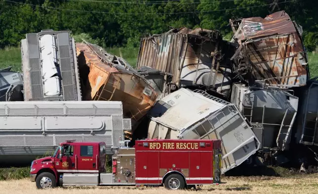 A fire truck sits near damage after a train derailed on Wednesday, June 3, 2026, near Victor, Iowa. (AP Photo/Charlie Neibergall)
