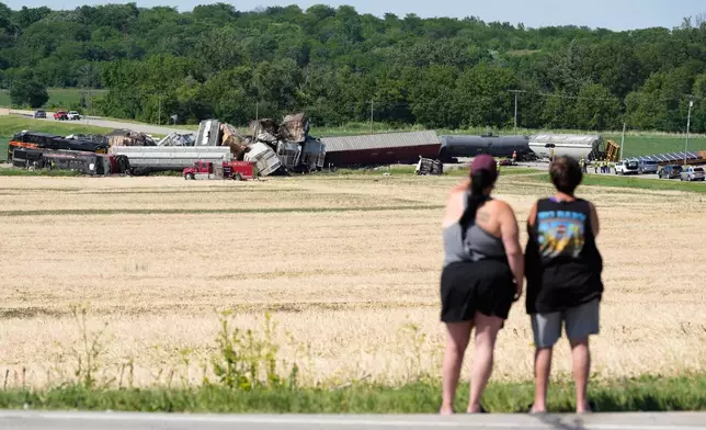 Spectators view damage after a train derailed on Wednesday, June 3, 2026, near Victor, Iowa. (AP Photo/Charlie Neibergall)