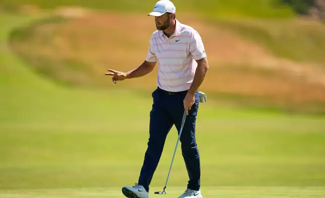 Scottie Scheffler waves after his putt on the third hole during the final round of the U.S. Open golf tournament at Shinnecock Hills Golf Club in Southampton, N.Y., Sunday, June 21, 2026. (AP Photo/George Walker IV)
