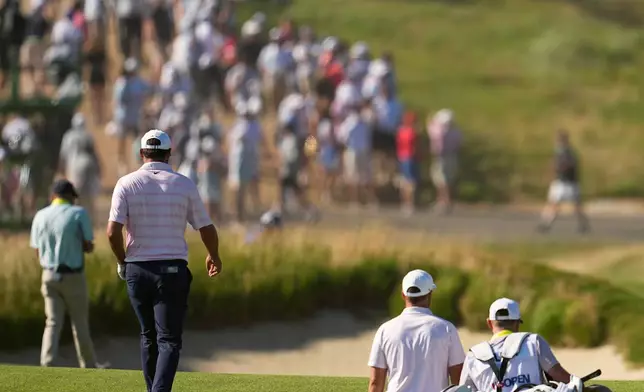 Scottie Scheffler and Wyndham Clark walk to green on the 12th hole during the final round of the U.S. Open golf tournament at Shinnecock Hills Golf Club in Southampton, N.Y., Sunday, June 21, 2026. (AP Photo/George Walker IV)