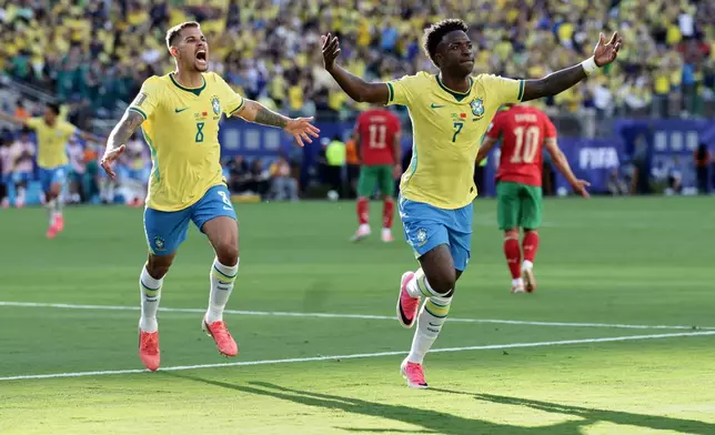 Brazil's Vinicius Junior (7) celebrates after scoring as teammate Bruno Guimaraes (8) watches during the World Cup Group C soccer match against Morocco in East Rutherford, N.J., near New York, Saturday, June 13, 2026. (AP Photo/Matt Slocum)