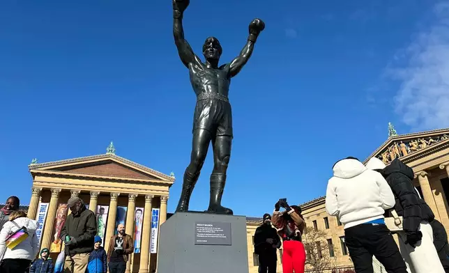 FILE - Visitors gather around the Rocky Statue during RockyFest 2024 at the Philadelphia Museum of Art, Dec. 3, 2024, in Philadelphia. (AP Photo/Tassanee Vejpongsa, File)