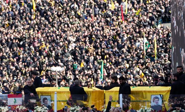 FILE - A trailer carrying the coffins containing the bodies of Hezbollah's former leader Hassan Nasrallah and his cousin and successor Hashem Safieddine drives through the crowd at the beginning of a funeral procession in the Sports City Stadium in Beirut, Sunday, Feb. 23, 2025. (AP Photo/Hussein Malla, File)