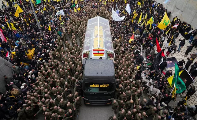 FILE - A trailer carrying the coffins containing the bodies of Hezbollah's former leader Hassan Nasrallah and his cousin and successor Hashem Safieddine drives through the crowd as it enters the Sports City Stadium during a funeral procession in Beirut, Feb. 23, 2025. (AP Photo/Hassan Ammar, File)