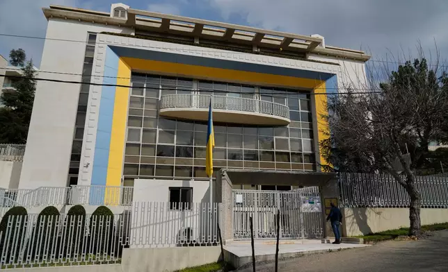 A man stands at the entrance of the Ukrainian Embassy in Yarzeh, east of Beirut, Monday, Feb. 28, 2022. (AP Photo/Bilal Hussein)