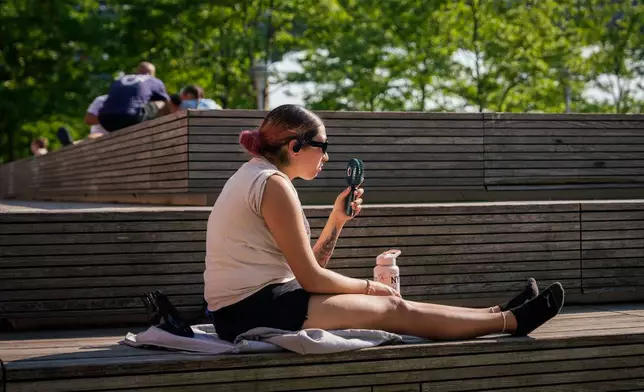 FILE - A person uses a fan during a heat advisory in the Brooklyn borough of New York, May 19, 2026. (AP Photo/Adam Gray, File)