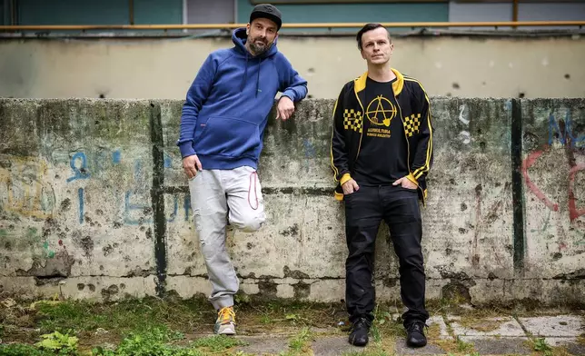 Brano Jakubovic, left, and Vedran Mujagic, members of Bosnian band Dubioza kolektiv, pose for a photo at a soccer playground where the video for the song "I Am From Bosnia, Take Me to America" was filmed, in Sarajevo, Bosnia, Thursday, June 11, 2026. (AP Photo/Armin Durgut)