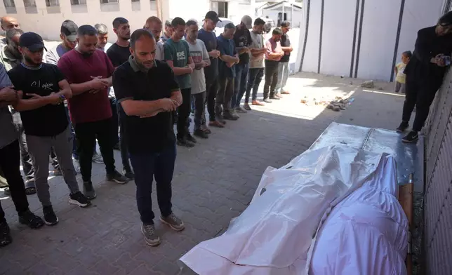 Mourners pray over the bodies of Palestinian men who were killed in an Israeli airstrike in the Maghazi refugee camp on Friday, during their funeral in Deir al-Balah, Gaza Strip, Saturday, June 27, 2026. (AP Photo/Abdel Kareem Hana)