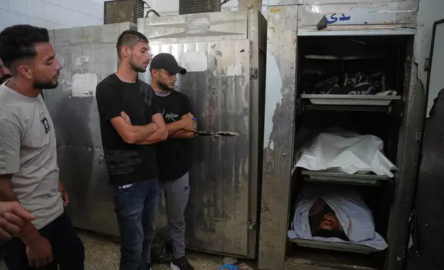 Mourners take the last look at the bodies of Palestinian men who were killed in an Israeli airstrike in the Maghazi refugee camp on Friday, during their funeral in Deir al-Balah, Gaza Strip, Saturday, June 27, 2026. (AP Photo/Abdel Kareem Hana)