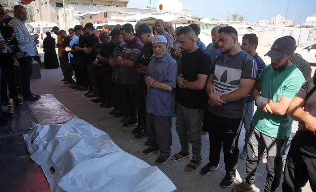 Mourners pray over the bodies of Palestinian men who were killed in an Israeli airstrike in the Maghazi refugee camp on Friday, during their funeral in Deir al-Balah, Gaza Strip, Saturday, June 27, 2026. (AP Photo/Abdel Kareem Hana)