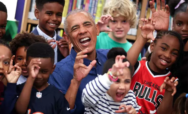 Former President Barack Obama poses for a photograph after reading to school children on opening day of the Barack Obama Presidential Center in John Lewis Plaza, Friday, June 19, 2026, in Chicago. (Win McNamee/Pool Photo via AP)