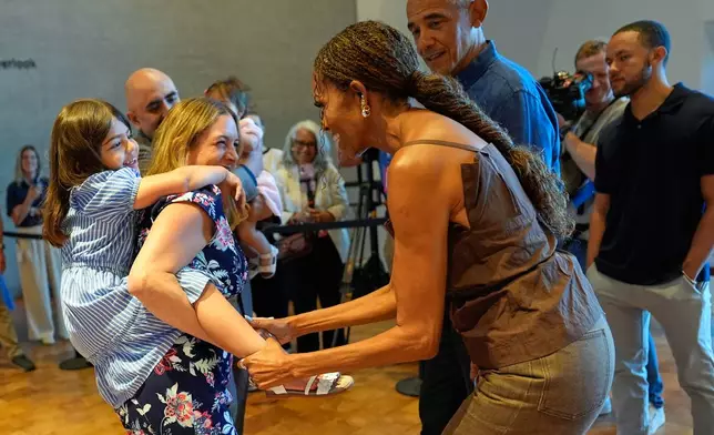 Former President Barack Obama and former first lady Michelle Obama greet the first group of visitors at the official opening of the Obama Presidential Center in Chicago, Friday, June 19, 2026. (AP Photo/Pablo Martinez Monsivais, Pool)