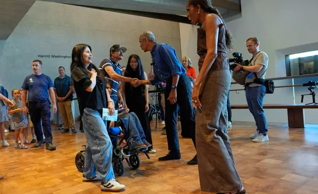 Former President Barack Obama and former first lady Michelle Obama greet the first group of visitors at the official opening of the Obama Presidential Center in Chicago, Friday, June 19, 2026. (AP Photo/Pablo Martinez Monsivais, Pool)