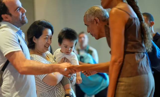 Former President Barack Obama and former first lady Michelle Obama greet the first group of visitors at the official opening of the Obama Presidential Center in Chicago, Friday, June 19, 2026. (AP Photo/Pablo Martinez Monsivais, Pool)