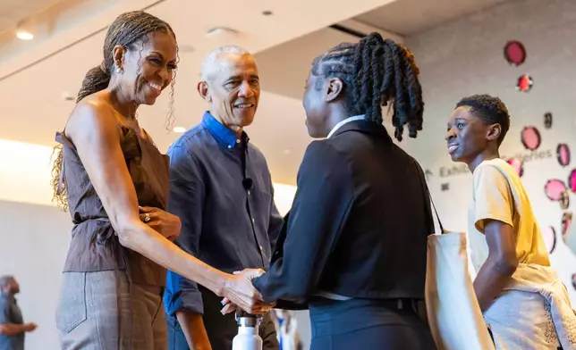 Former President Barack Obama and First Lady Michelle Obama greet community members in the Hope and Change lobby before they walk through the museum at the Obama Presidential Center in Chicago on Friday, June 19, 2026. (Eileen T. Meslar /Chicago Tribune via AP, Pool)