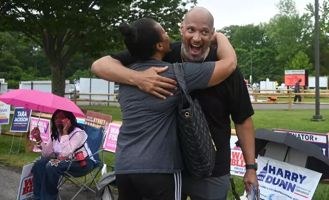 Harry Dunn, former U.S. Capitol police officer and candidate for U.S. Congress greets a voter Tuesday, June 23, 2026, in Upper Marlboro, Md. (AP Photo/Gail Burton)