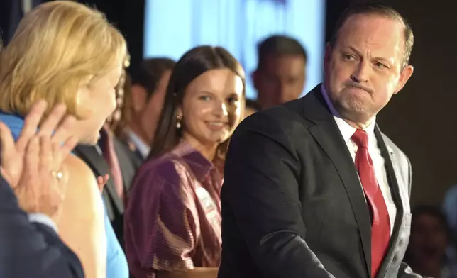 South Carolina Attorney General Alan Wilson, right, looks back at his wife, Jennifer, as he speaks to supporters celebrating his GOP gubernatorial runoff victory in a hotel ballroom on Tuesday, June 23, 2026, in Columbia, S.C. (AP Photo/Meg Kinnard)