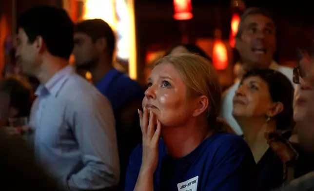 A supporter watches as Democratic congressional candidate Jack Schlossberg speaks during an election night watch party Tuesday, June 23, 2026, in New York. (AP Photo/Heather Khalifa)