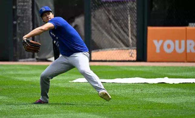 Los Angeles Dodgers two-way player Shohei Ohtani, from Japan, warms up before a baseball game against the Chicago White Sox, Saturday, June 13, 2026, in Chicago. (AP Photo/Matt Marton)
