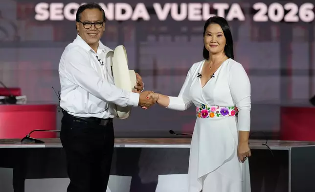 Presidential candidate Keiko Fujimori of the Popular Force party, right, shakes hands with rival Roberto Sanchez of Together for Peru party, before a presidential debate, in Lima, Peru, Sunday, May 31, 2026. (AP Photo/Martin Mejia)