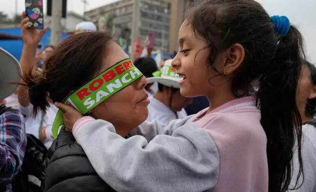 A girl embraces her mother during a campaign rally for presidential candidate Roberto Sanchez of the Together for Peru party in Lima, Peru, Thursday, June 4, 2026. (AP Photo/Martin Mejia)