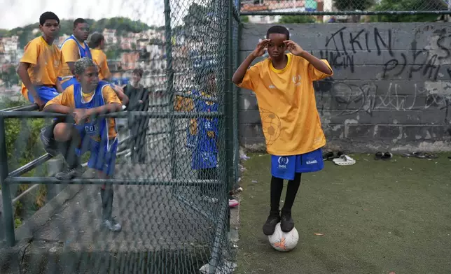 Luis Gustavo balances on a ball during a soccer training session organized by the Street Child United Brazil social project in the Complexo da Penha favela of Rio de Janeiro, Wednesday, June 3, 2026. (AP Photo/Silvia Izquierdo)