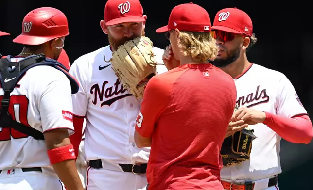 Washington Nationals starting pitcher Zack Littell has a conference with Nationals pitching coach Simon Mathews during the second inning of a baseball game against the Kansas City Royals, Wednesday, June 17, 2026, in Washington. (AP Photo/John McDonnell)