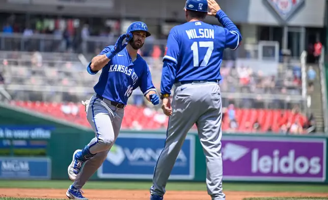 Kansas City Royals' John Rave is greeted by third base coach Vance Wilson after hitting a solo home run during the second inning of a baseball game against the Washington Nationals, Wednesday, June 17, 2026, in Washington. (AP Photo/John McDonnell)