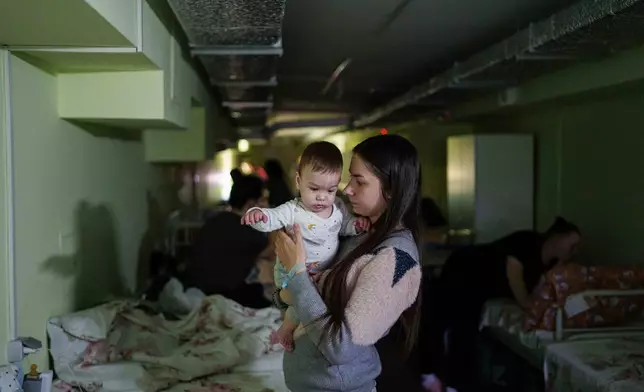 Marharyta Nekhoroshyva holds her son Mark inside a shelter at the children's regional hospital of Zaporizhzhia, Ukraine, on Thursday, May 7, 2026. (AP Photo/Evgeniy Maloletka)