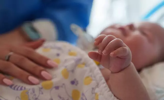 Dasha Kosmin touches her son Mark at the ICU department of the children's regional hospital in Zaporizhzhia, Ukraine, Thursday, May 7, 2026. (AP Photo/Evgeniy Maloletka)