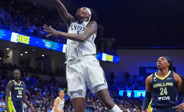 Minnesota Lynx forward Natasha Howard, center, goes up to score in front of Dallas Wings guard Arike Ogunbowale (24) during the second half of a WNBA basketball game in Arlington, Texas, Sunday, June 28, 2026. (AP Photo/LM Otero)