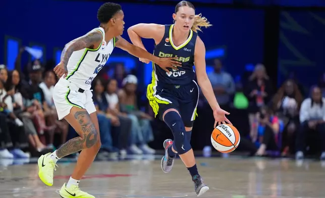 Dallas Wings guard Paige Bueckers (5) drives against Minnesota Lynx guard Courtney Williams, left, during the first half of a WNBA basketball game in Arlington, Texas, Sunday, June 28, 2026. (AP Photo/LM Otero)
