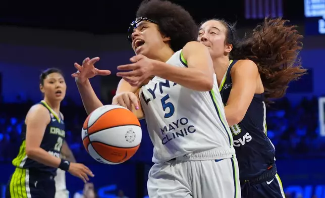 Minnesota Lynx guard Olivia Miles (5) is foulded by Dallas Wings forward Maddy Siegrist, right, during the second half of a WNBA basketball game in Arlington, Texas, Sunday, June 28, 2026. (AP Photo/LM Otero)
