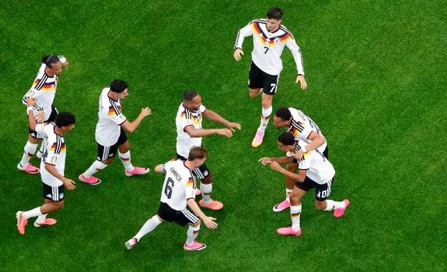 Germany's Jamal Musiala (10), lower right, is congratulated by teammates after scoring during the World Cup Group E soccer match between Germany and Curacao in Houston, Sunday, June 14, 2026. (AP Photo/Michael Wyke)