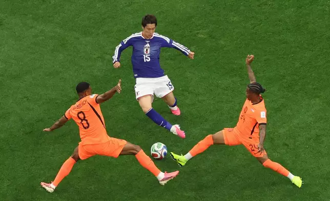 Netherlands' Ryan Gravenberch (8) and Crysencio Summerville (24) compete for the ball against Japan's Daichi Kamada (15) during the World Cup Group F soccer match between the Netherlands and Japan in Arlington, Texas, near Dallas, Sunday, June 14, 2026. (AP Photo/Sam Hodde)