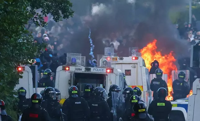 Police attempt to disperse protesters near Newtownabbey, in Belfast, Northern Ireland, Wednesday, June 10, 2026, following a stabbing incident on Monday night. (AP Photo/Peter Morrison)