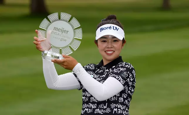Miyu Yamashita, of Japan, holds her trophy after winning the Meijer LPGA Classic golf tournament, Sunday, June 21, 2026, in Belmont, Mich. (AP Photo/Al Goldis)