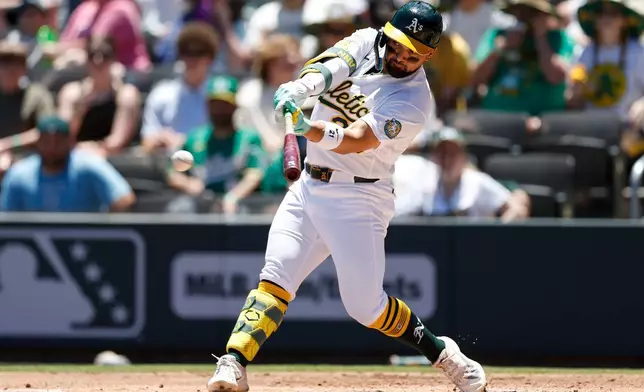 Athletics' Carlos Cortes hits a two run single during the first inning of a baseball game against the Colorado Rockies, Sunday, June 14, 2026, in Las Vegas. (AP Photo/Caroline Brehman)